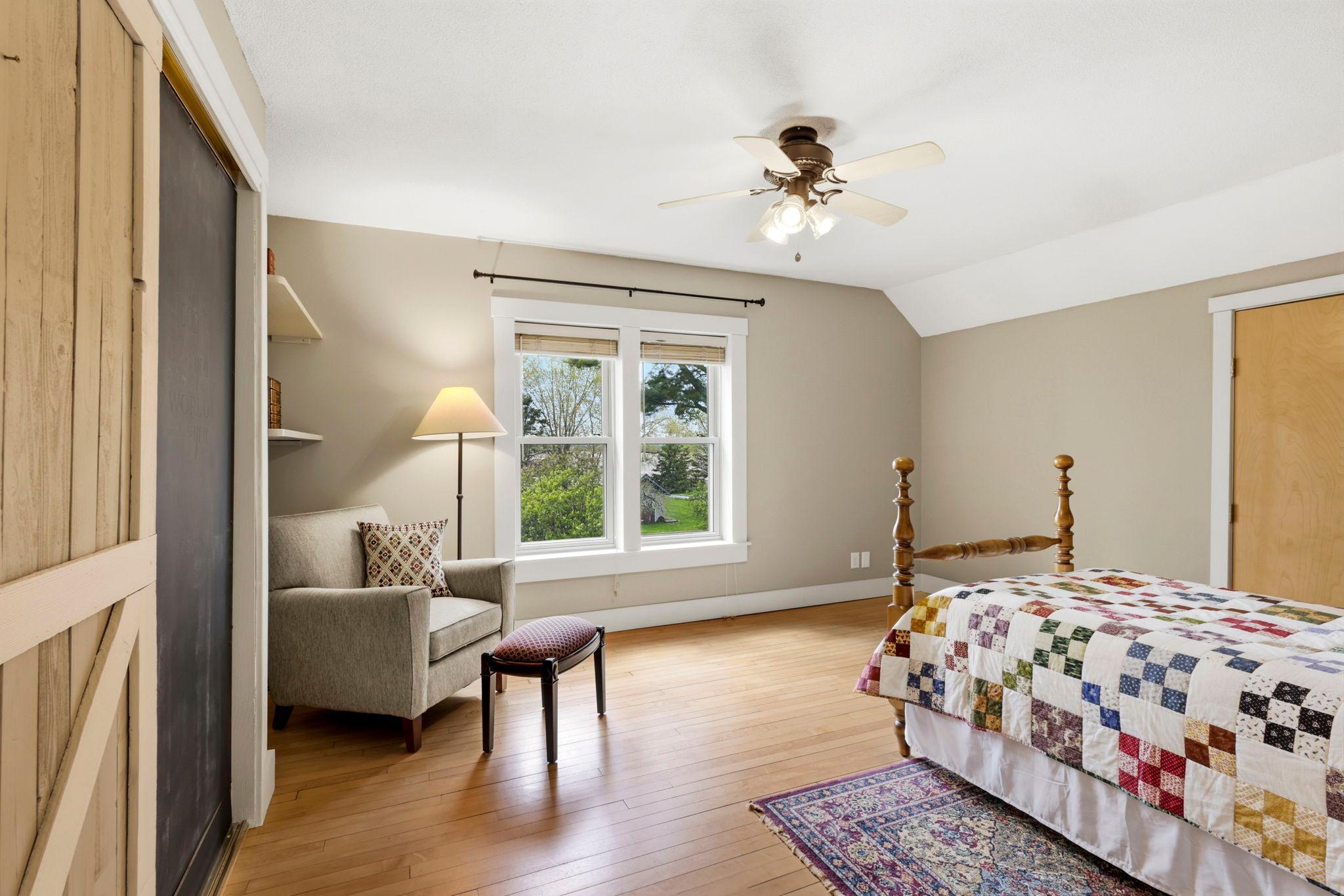 Large upper-level bedroom filled with natural light and flexible space for a sitting area or reading nook.