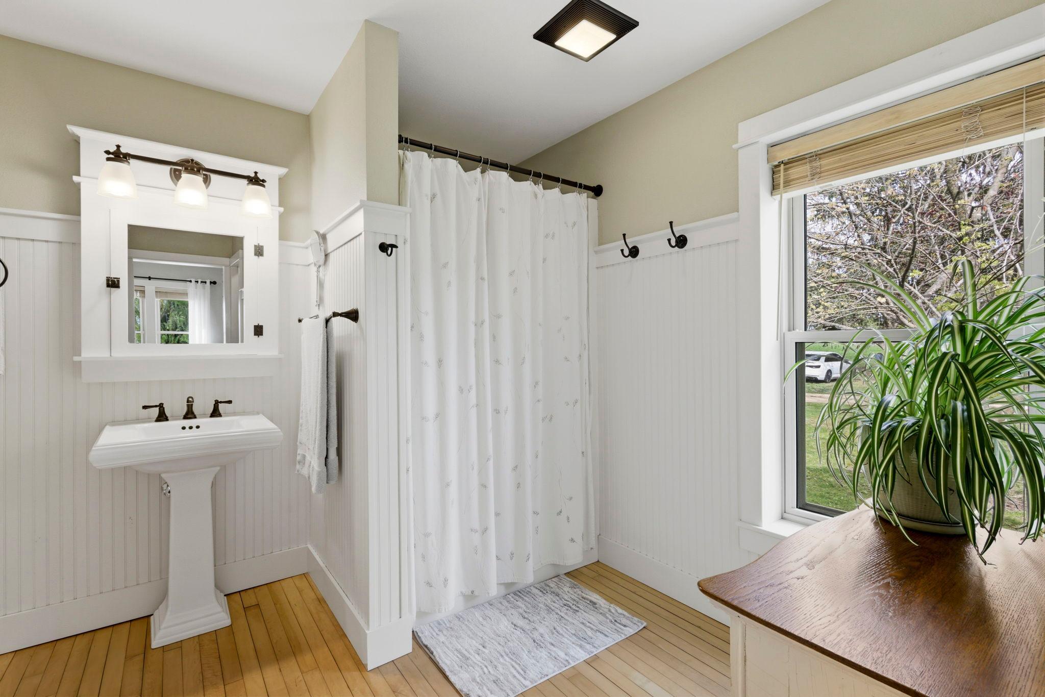 Bright and charming bath with vintage-inspired pedestal sink and beadboard detail
