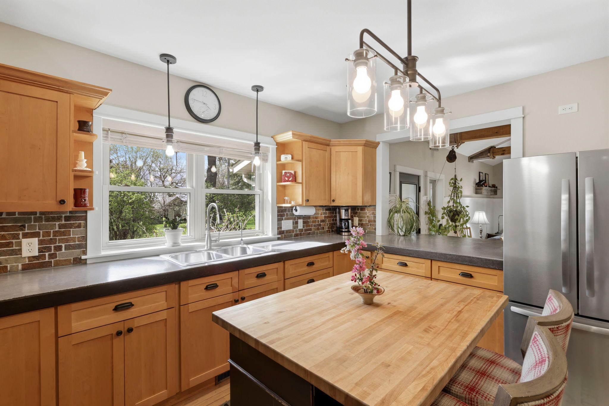 Bright and inviting kitchen with expansive counter space, large windows, and timeless finishes.