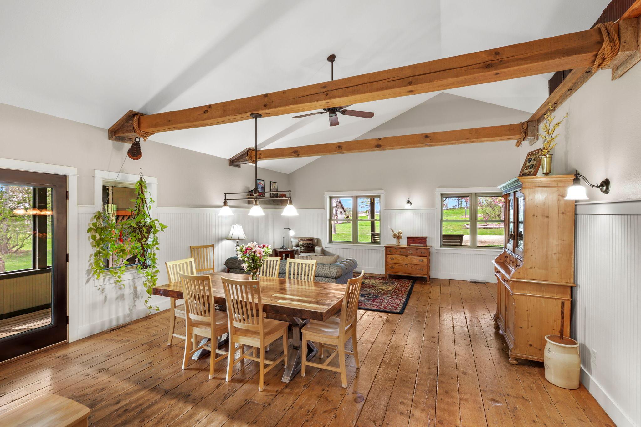 Open-concept gathering space designed for comfortable living and entertaining with stunning beam accents and natural light.