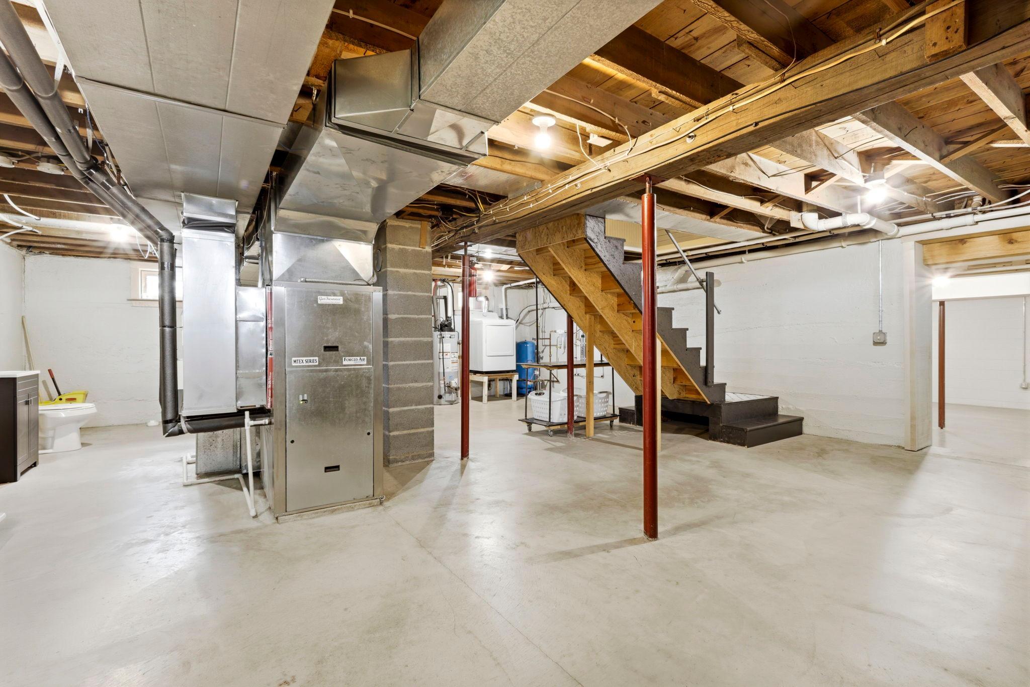 Clean and spacious basement with updated mechanicals and room for projects, storage, or recreation
