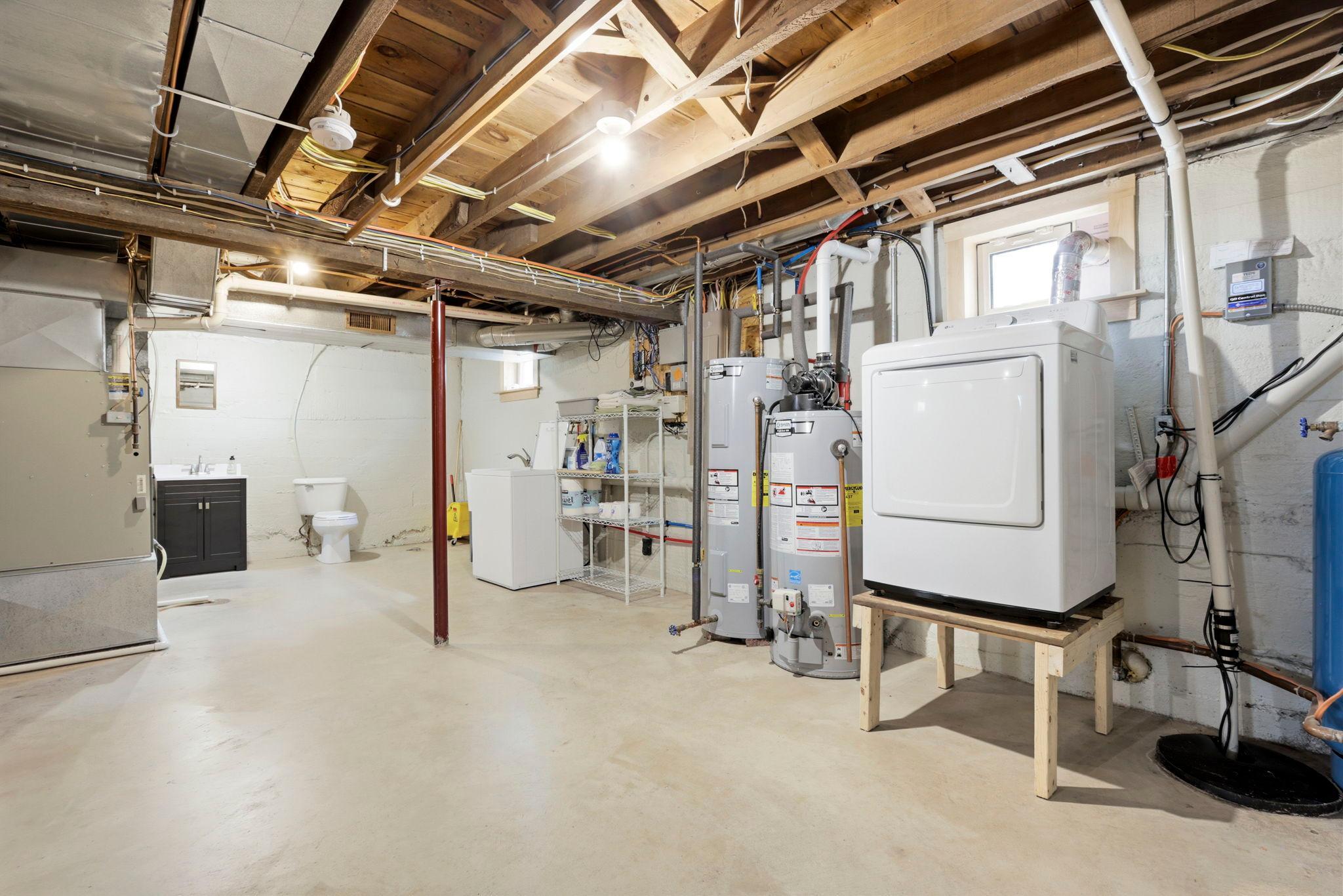 Functional lower level with laundry area, utility sink, and ample room for workshop or hobby space.