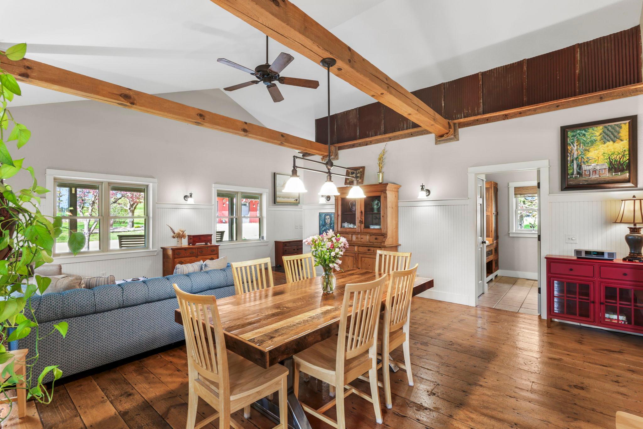 Vaulted great room with exposed wood beams, open sightlines, and abundant natural light throughout.