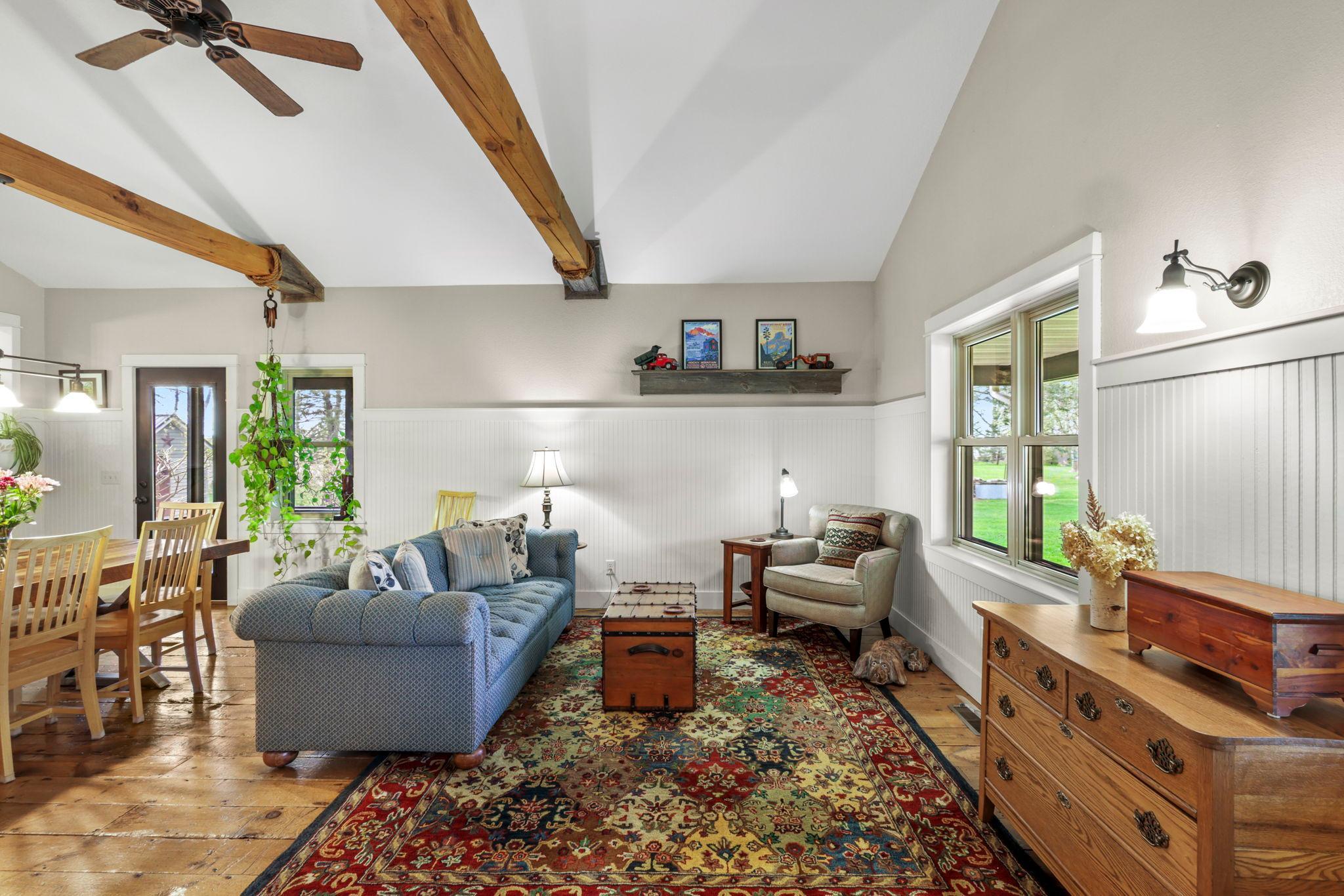 Cozy sitting area highlighted by exposed beams, hardwood floors, and scenic views from every window.