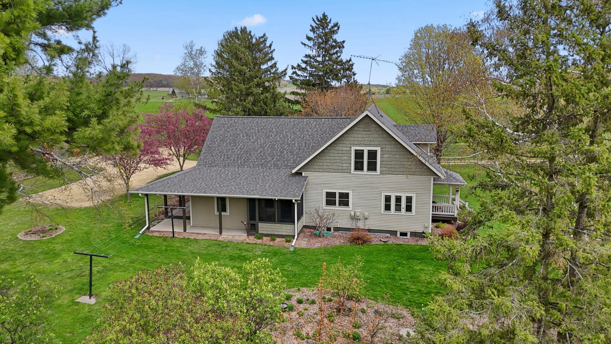 Peaceful rural views surround this beautifully updated farmhouse with inviting covered porches and timeless curb appeal