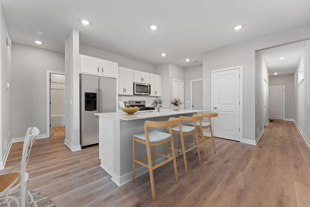 Countertop seating, kitchen pantry, and stainless appliances (including a vented microwave fan and gas range) will make mealtime more enjoyable! Virtually staged photo, color and finish will vary.