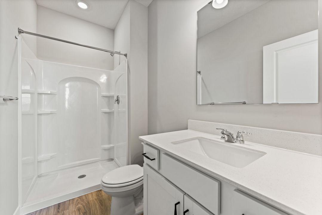 The ensuite primary bath featuring a walk-in shower. Spec home. Actual home is under construction - color and finish will vary.