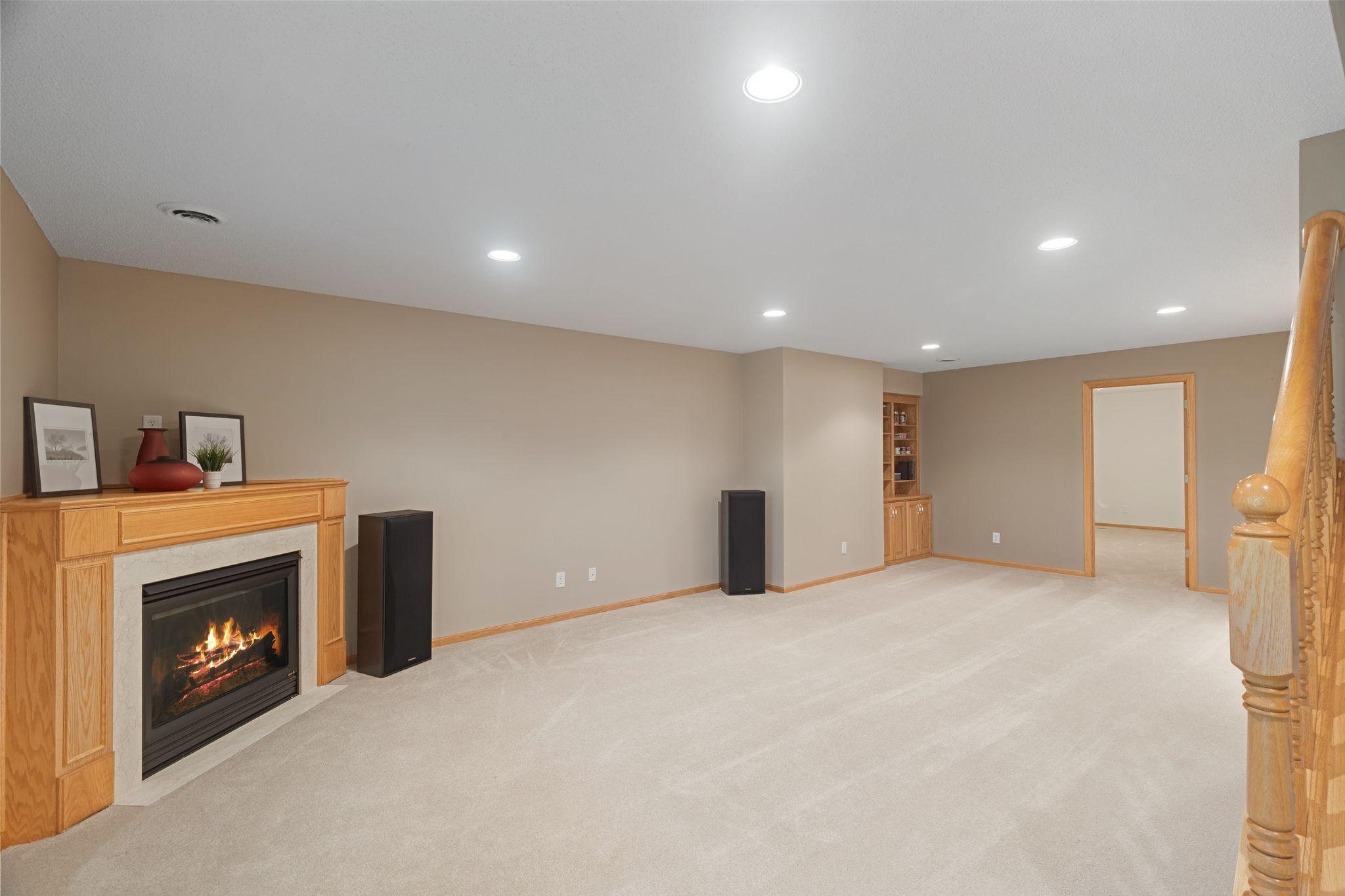Huge lower-level family room with fireplace, built-ins, and plenty of room for entertaining or relaxing.
