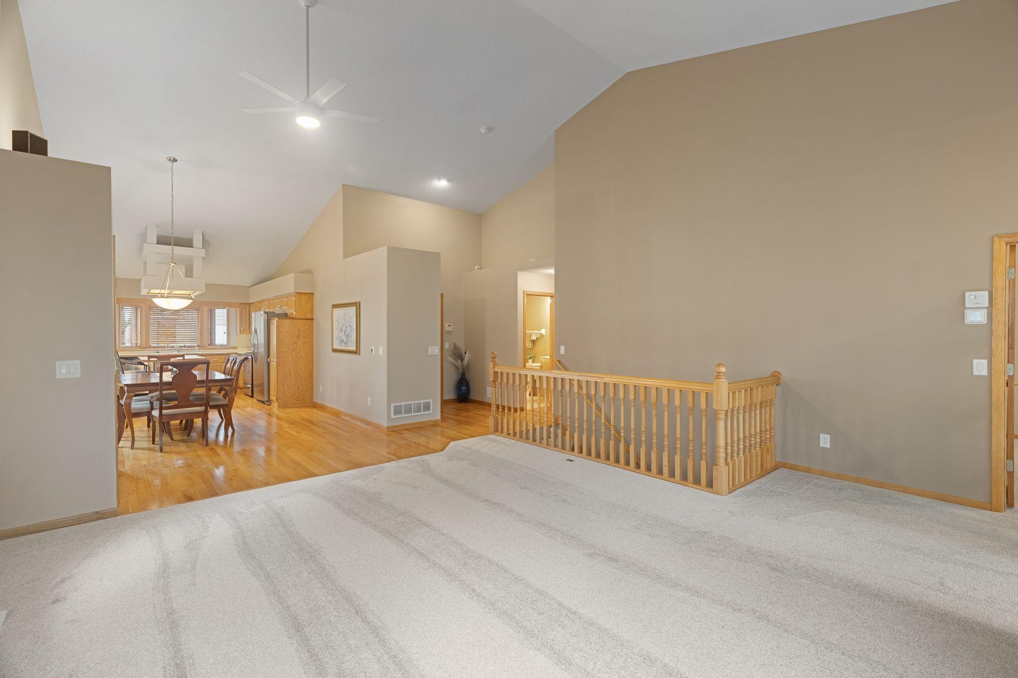 Expansive main living area with open sightlines, natural light, and beautiful hardwood flooring.