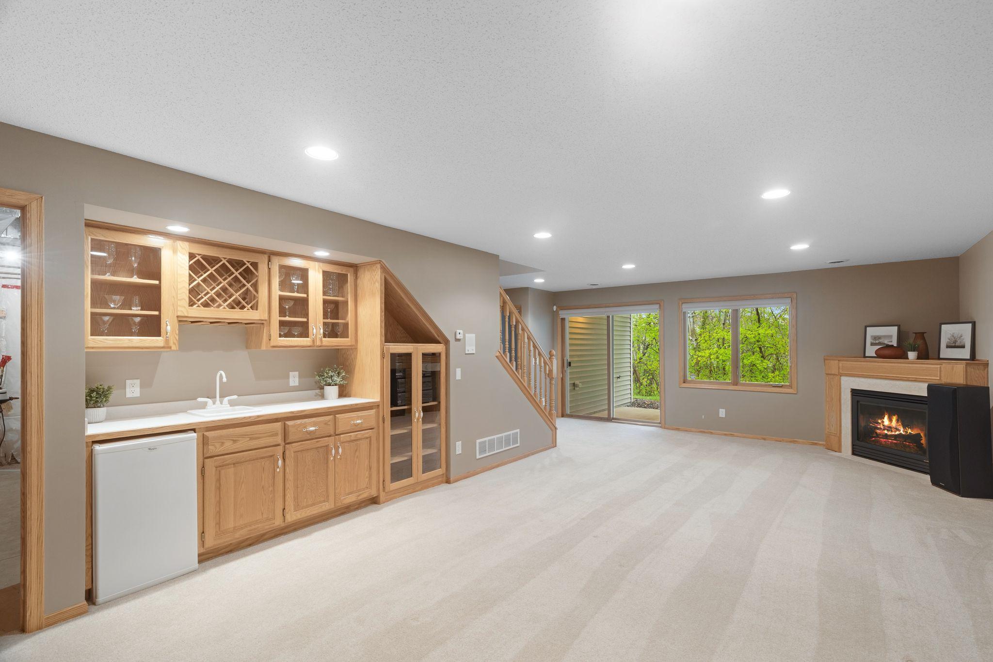 Finished lower level with wet bar area, additional gathering space, and walkout access to nature views.