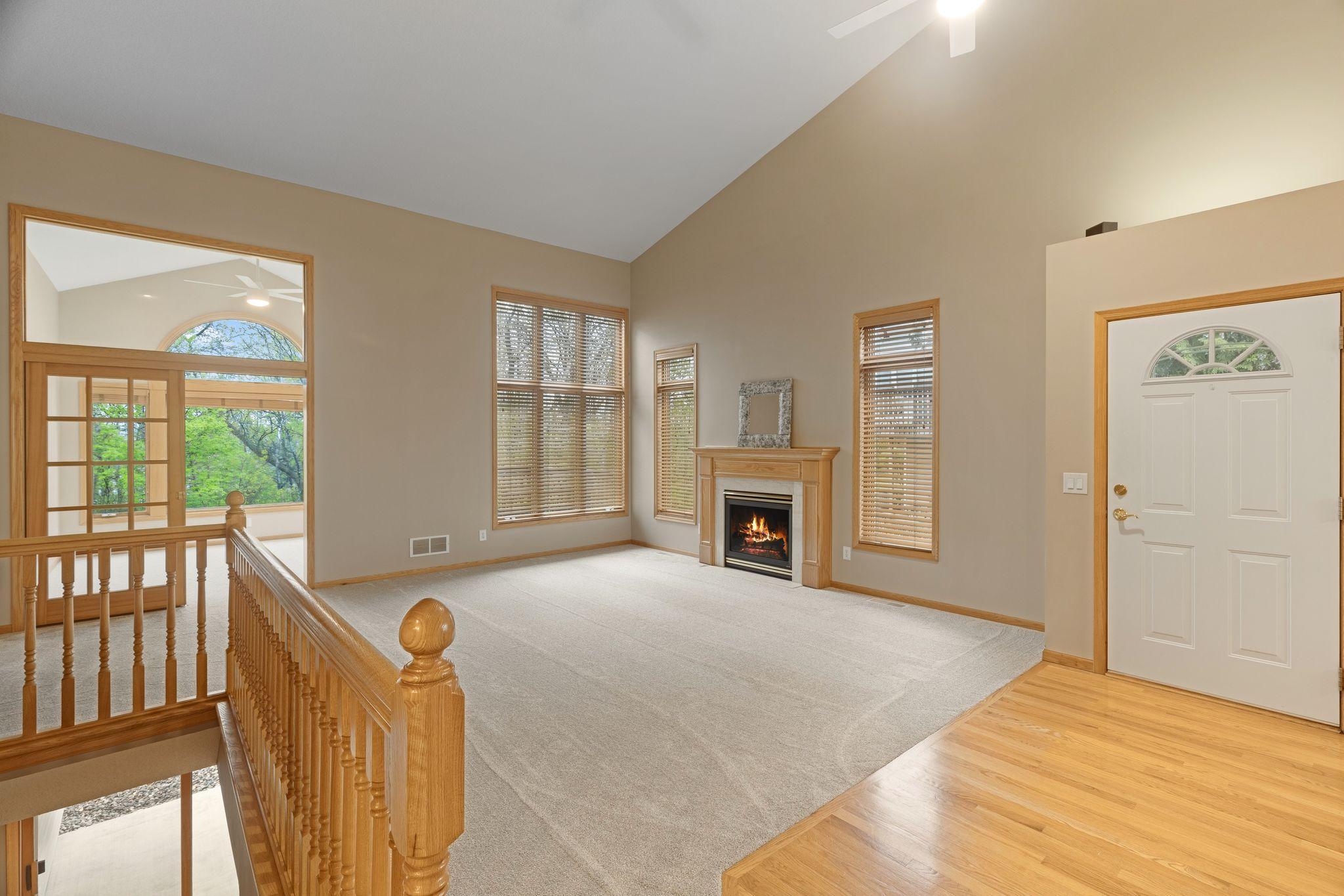 Spacious living room with oversized windows, fireplace centerpiece, and easy flow into the sunroom.