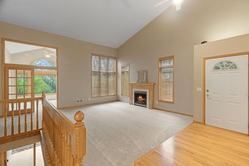 Spacious living room with oversized windows, fireplace centerpiece, and easy flow into the sunroom.