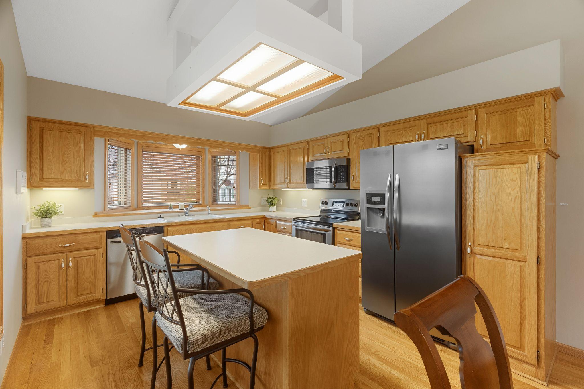 Functional kitchen with center island, abundant cabinetry, stainless steel appliances, and generous prep space.