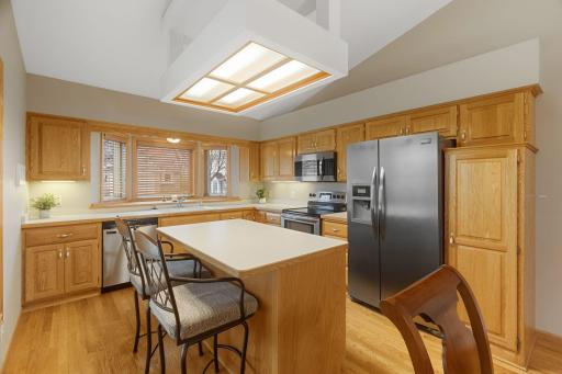 Functional kitchen with center island, abundant cabinetry, stainless steel appliances, and generous prep space.