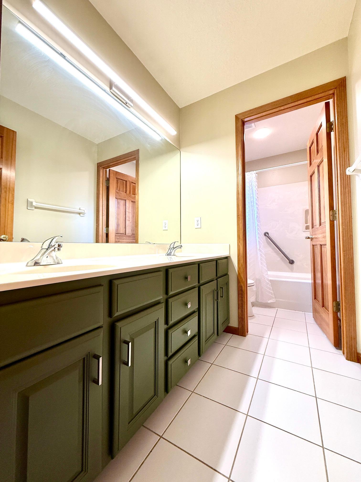 Upper level full guest bathroom with tile floors