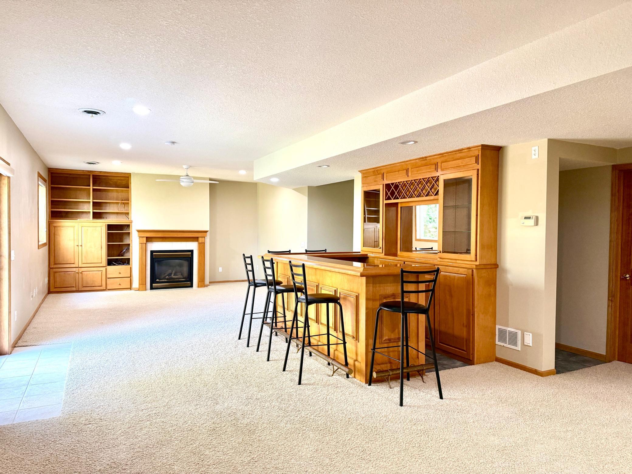 Lower level walk out family room with gas fireplace, builtins and a spot for a bar refrigerator
