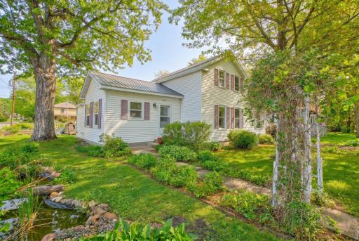 Outside, enjoy a beautifully landscaped yard with garden beds, a peaceful water feature, firepit area, and plenty of room to unwind.