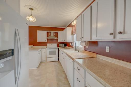 The charming kitchen features ample cabinet and counter space and connects effortlessly to the beautiful formal dining room highlighted by a tray ceiling and classic architectural detail.