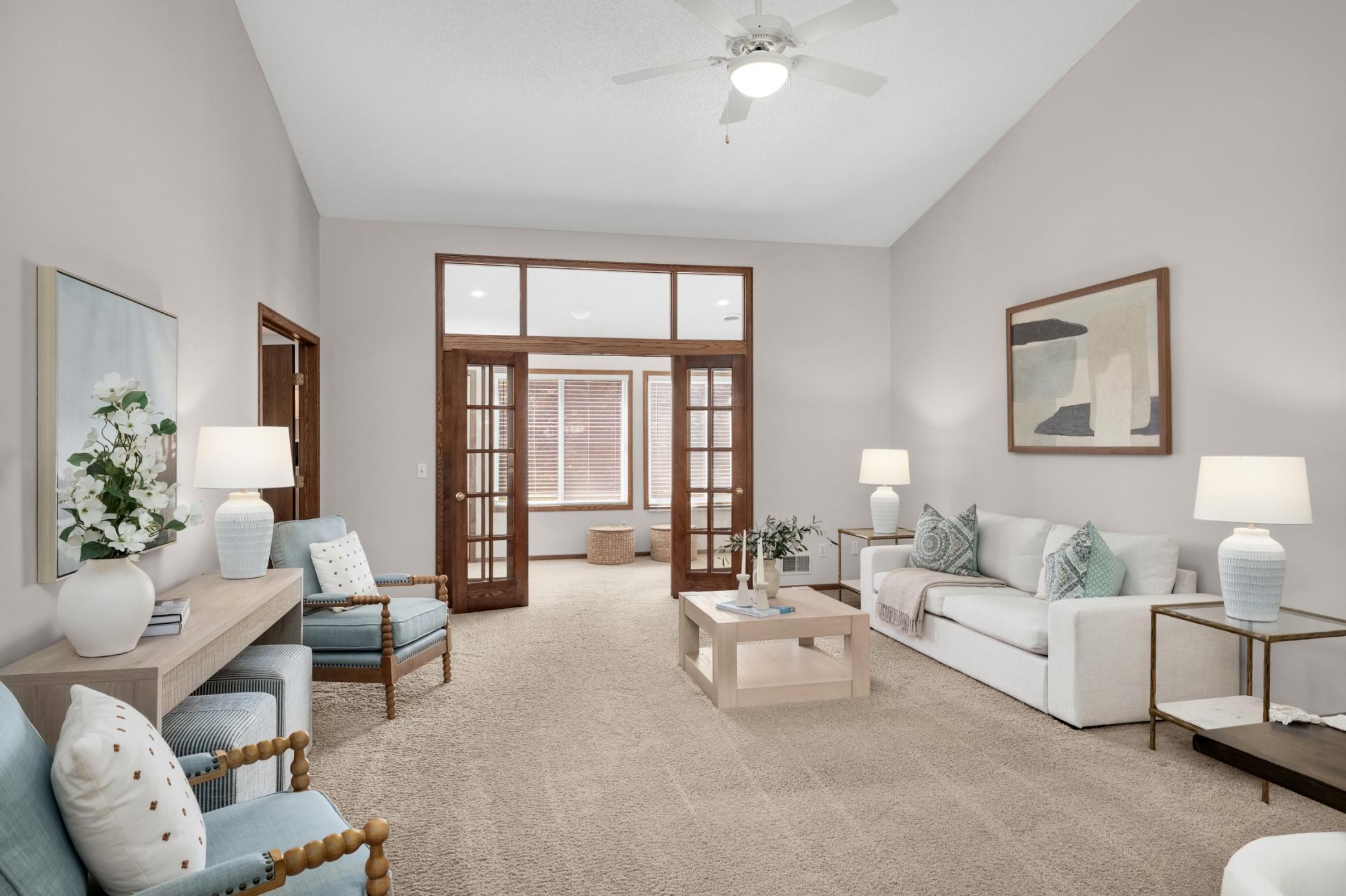 Open living room with high ceilings leads into the sunroom, bringing in tons of natural light