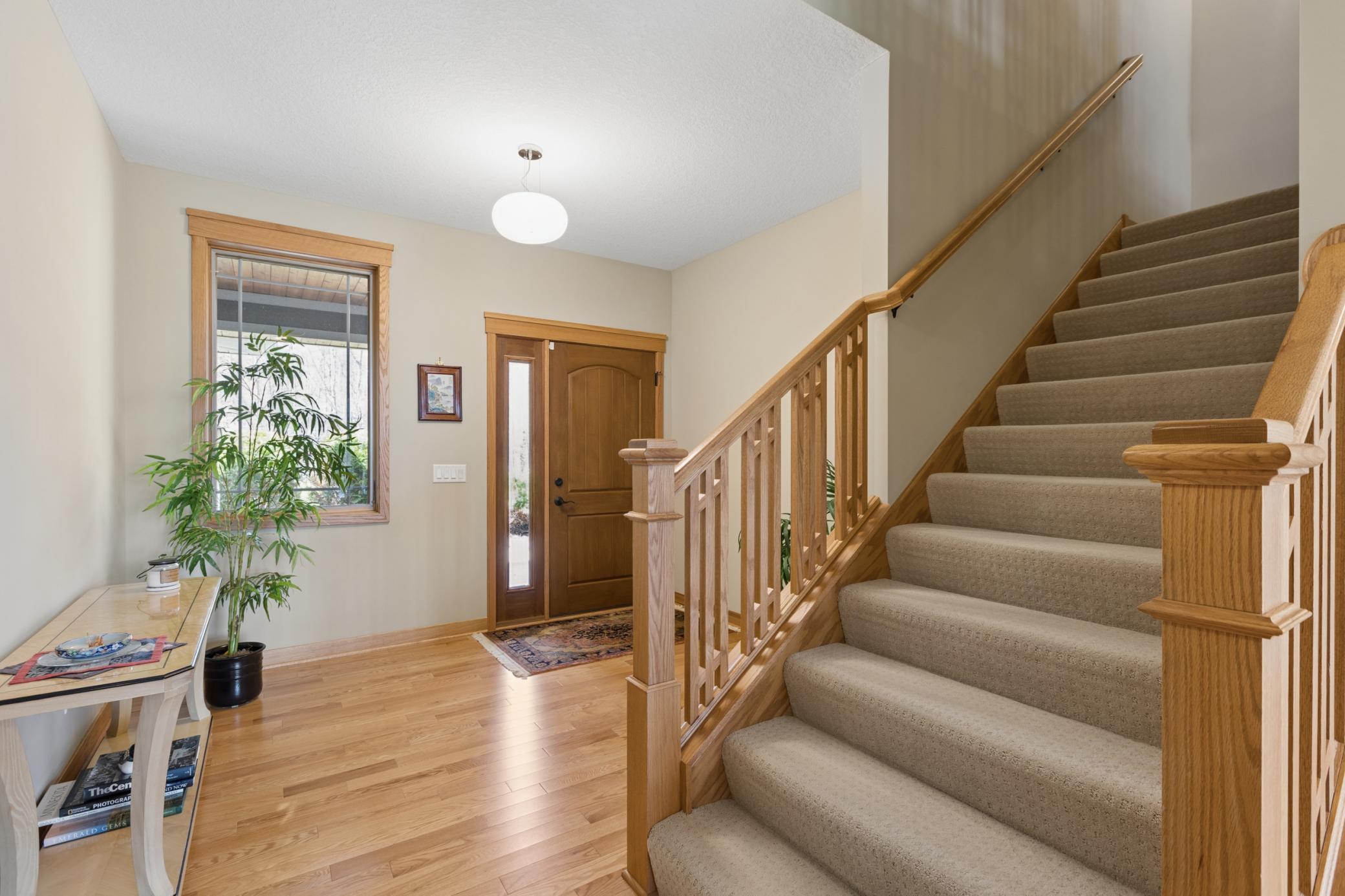 The entry in the home is large and inviting. Gorgeous floors and warm paint colors too! Note the railing on the steps going to the upper level. Stunning!