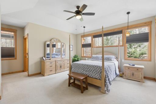 The main floor primary bedroom! Spacious with a large wall of amazing windows, cool lighting and a tray ceiling!