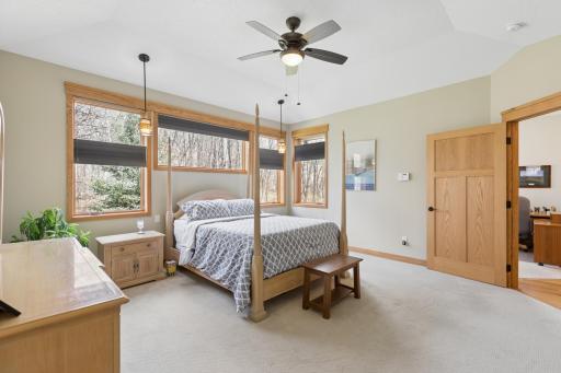 Another view of the main floor primary bedroom. The warm paint color and pretty flooring complement the solid oak 3 panel door. Many of the doors in this home are 36".