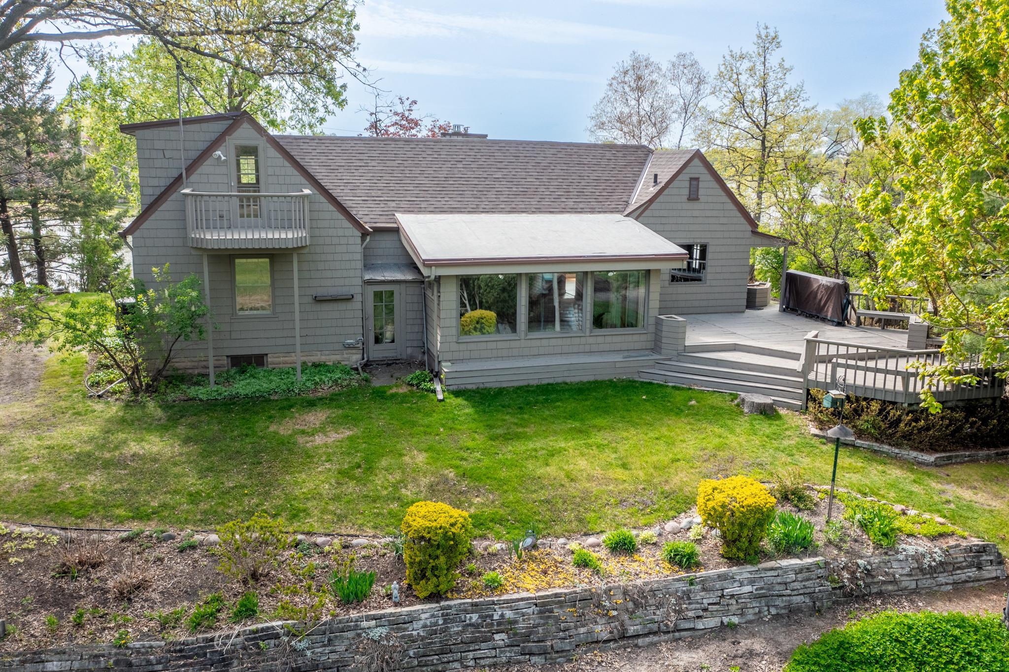 Balcony. Sunroom. Large deck. Stone retaining wall. You can have it all.