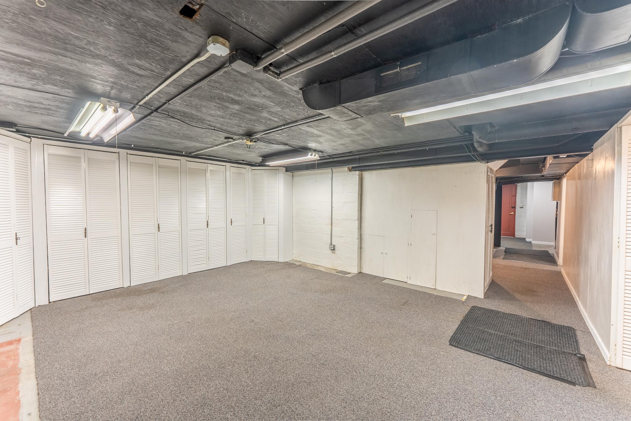 An efficient basement flex space designed as a functional maker studio or hobby workshop.