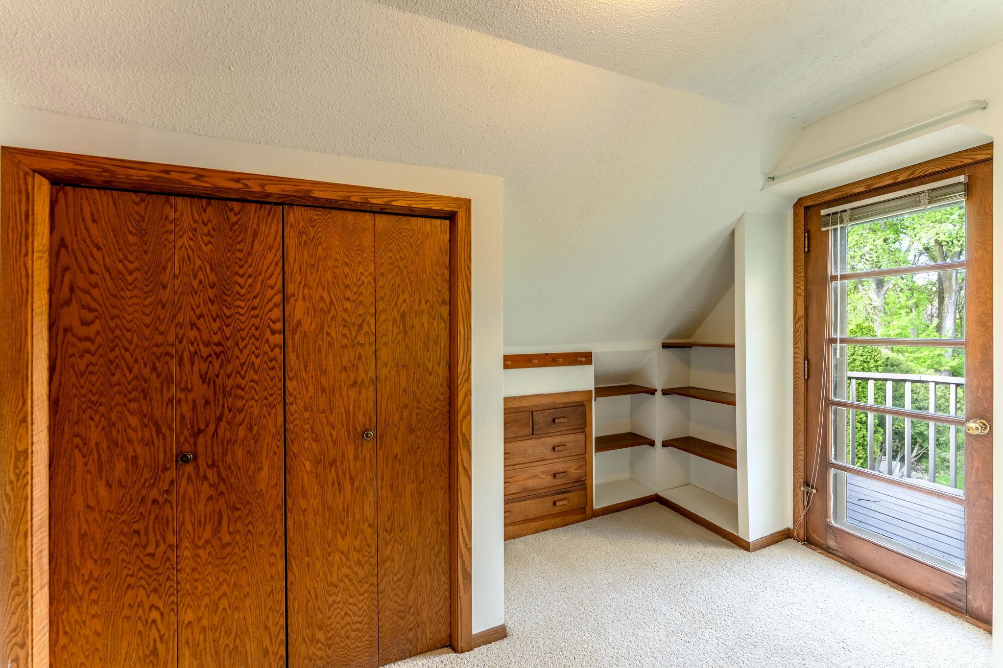 Bedroom 4 (upper level) has vintage shelving, a built in dresser and a private balcony.