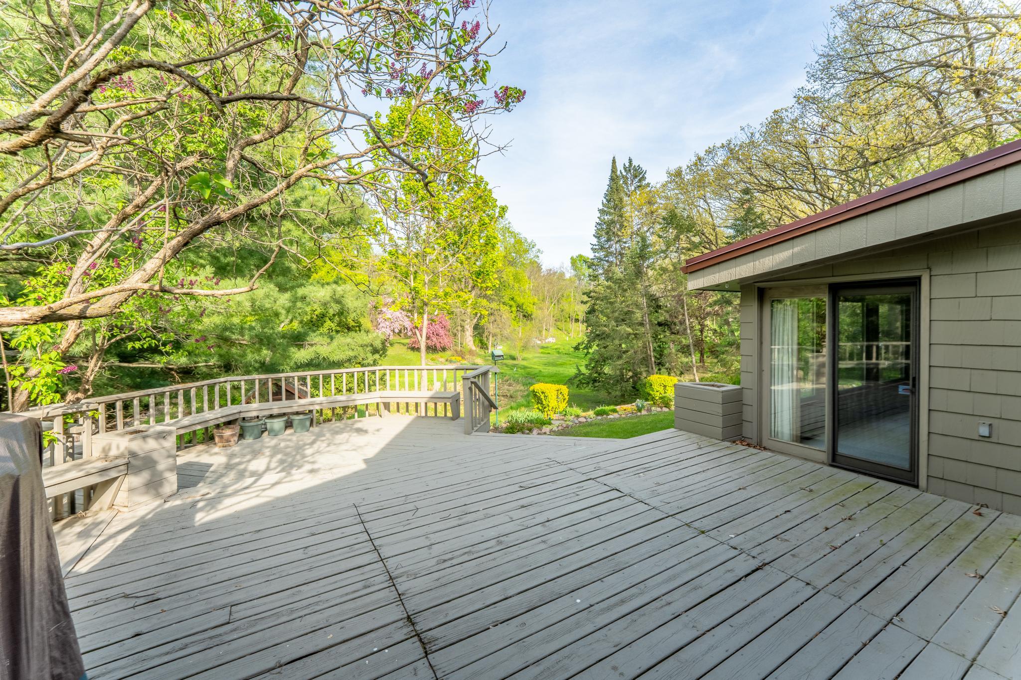 Deck has access from the kitchen and the sunroom and leads down to the amazing backyard gardens.
