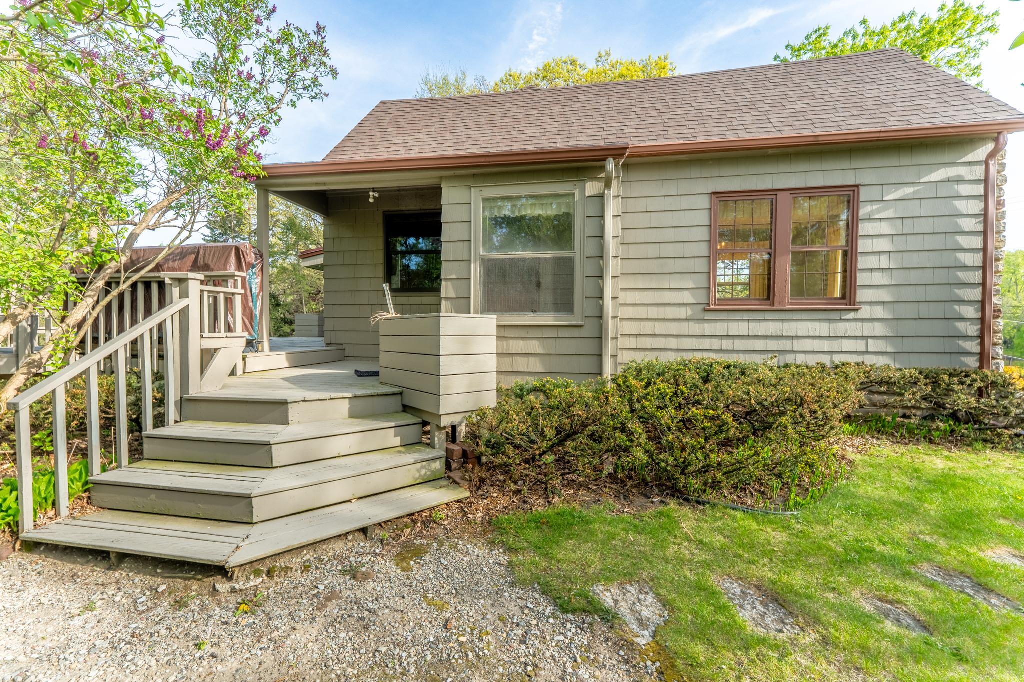 Access to the expansive deck from the side yard. Not shown is a purpose-built firewood shed, the kind of small detail that tells you everything about how this home has been cared for.