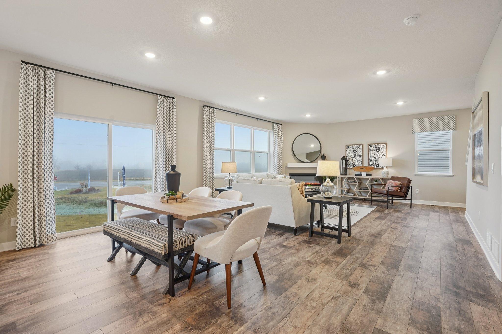 The sliding glass door and oversized windows in the living room provide exceptional natural light into the main level of the home. Photo of model home, fireplace surround and finishes will vary.