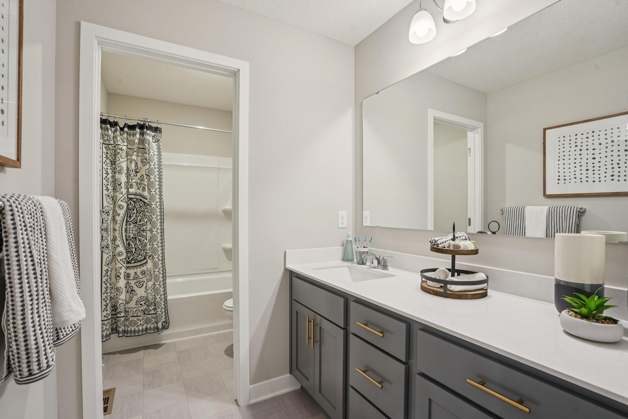 The second bathroom on the upper level will include dual sinks. There is a private toilet/shower room which is very convenient for busy mornings. Photo of model home, colors and finishes will vary.