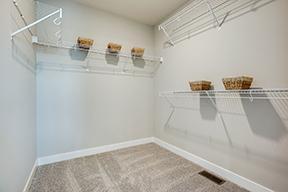The first of two walk-in closets in the primary bedroom. Photo of model home, colors and finishes are similar.