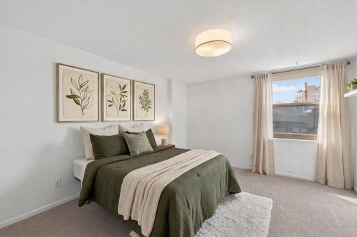 The oversized bedroom has plush carpet and great natural light