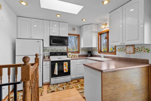 Lots of natural light from the skylight plus recessed lighting. Appliances include a microwave, electric stove, & refrigerator.