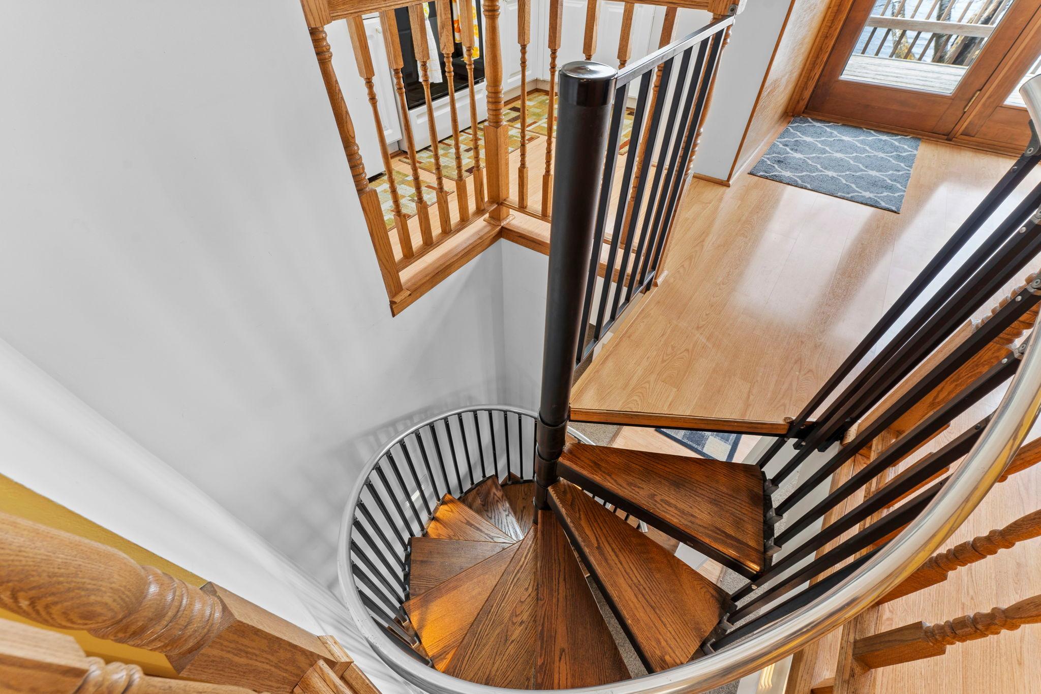 Well designed spiral stairway with stair lighting on the wall