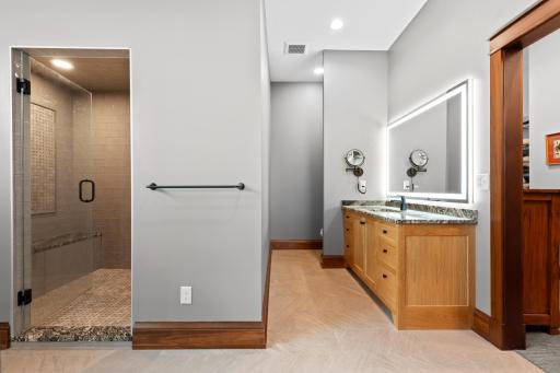 Primary bathroom features tiled steam shower, his and her vanities and large walk in closet