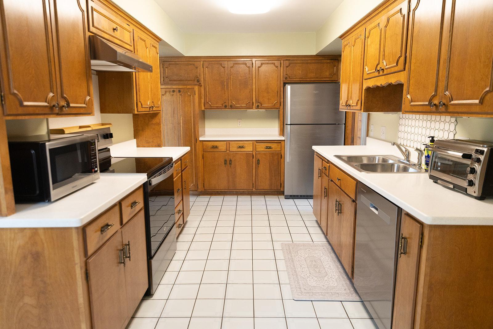 Kitchen features stainless appliances, vented range hood, Corian countertops, and plenty of cabinetry
