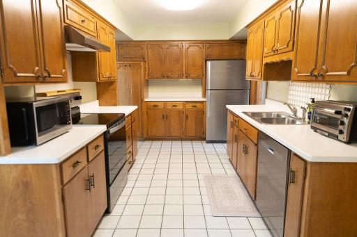 Kitchen features stainless appliances, vented range hood, Corian countertops, and plenty of cabinetry