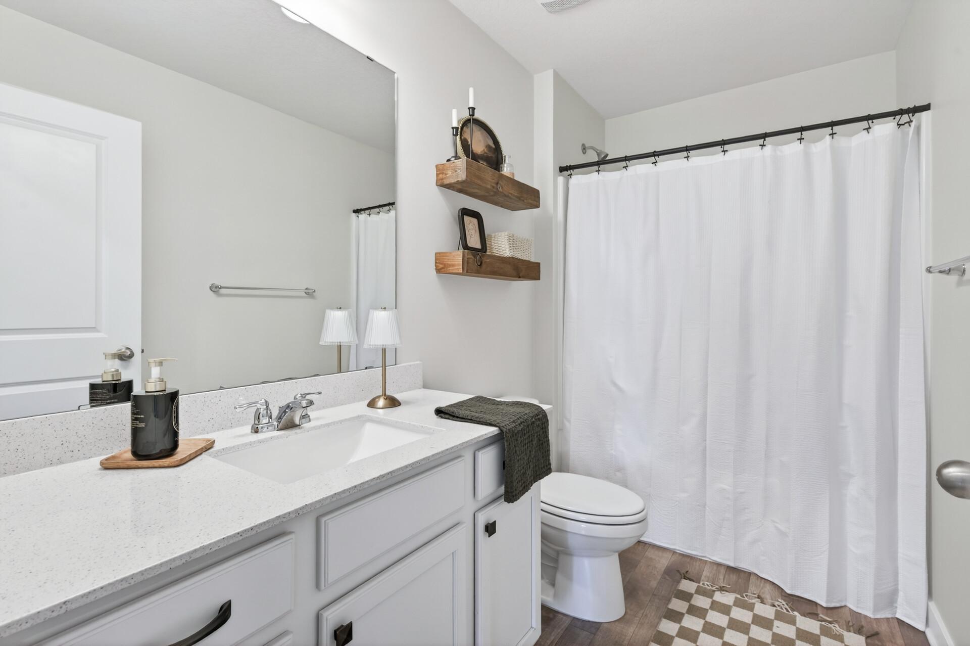 Stylish full bathroom with clean finishes and convenient storage space.