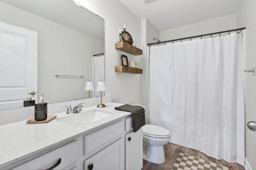 Stylish full bathroom with clean finishes and convenient storage space.