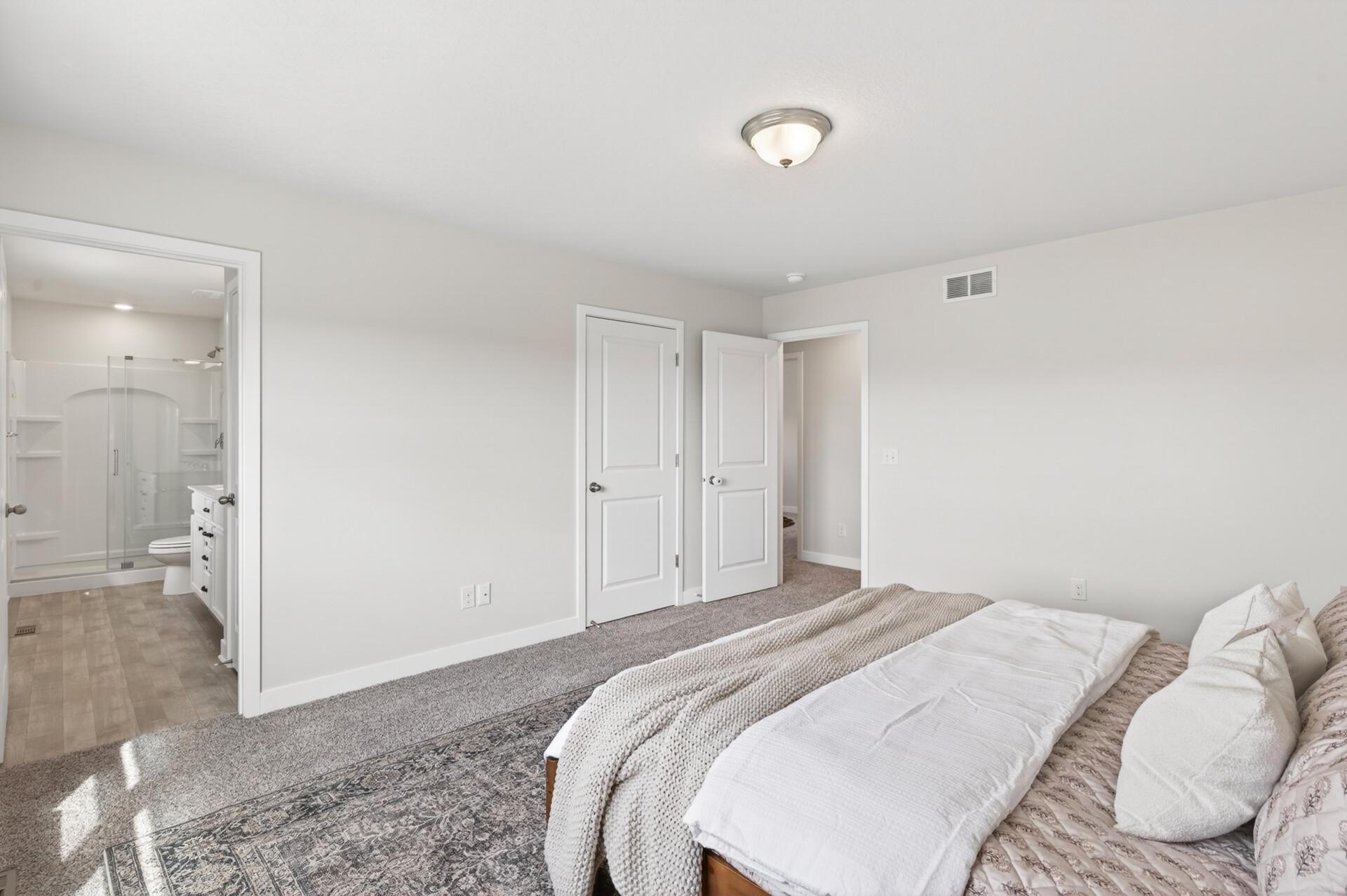 Spacious primary bedroom with generous closet space and a bright, airy atmosphere.
