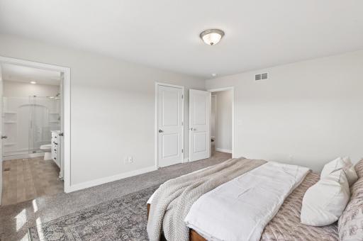 Spacious primary bedroom with generous closet space and a bright, airy atmosphere.