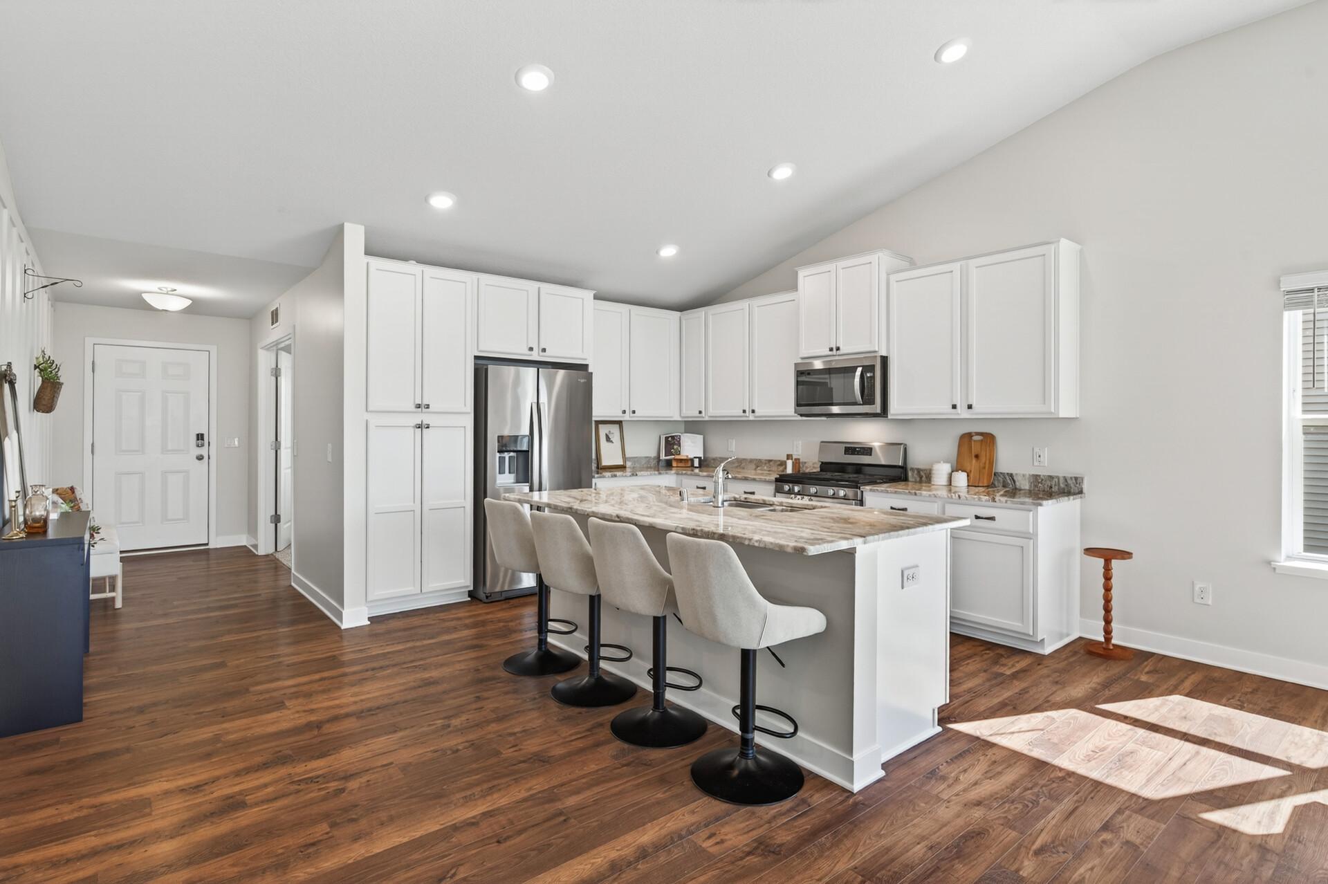 Modern kitchen with a large center island, stainless steel appliances, and abundant cabinetry.