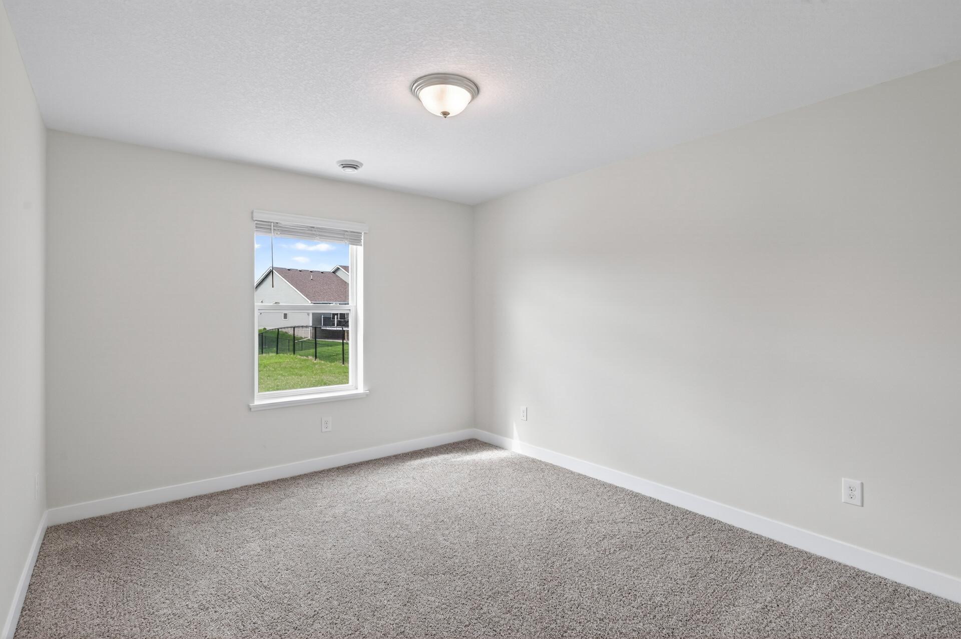 Bright lower-level bedroom with abundant natural light.