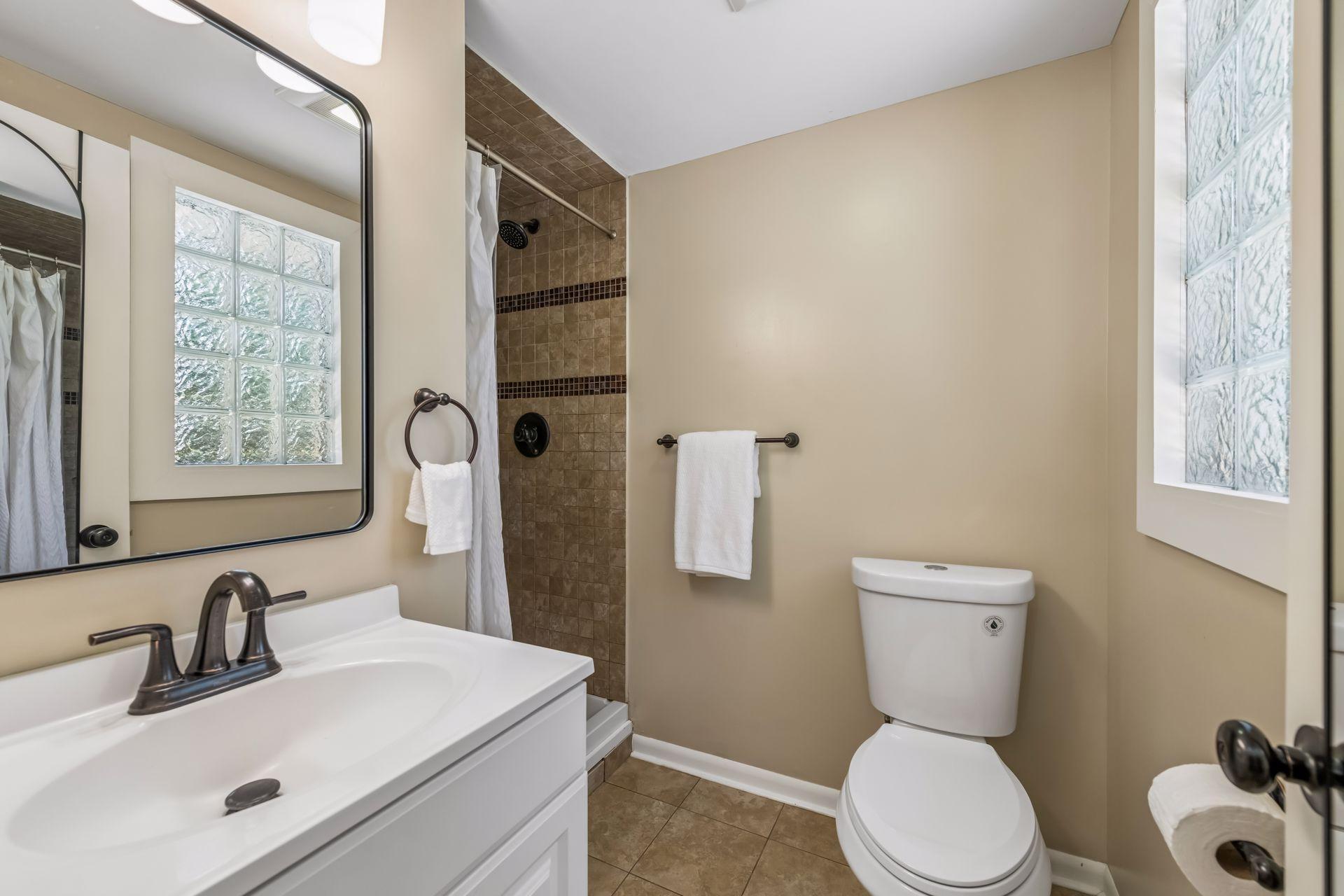Primary 3/4 bath with toilet, vanity and tiled shower