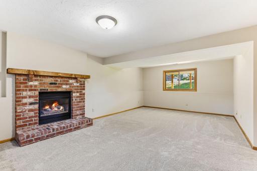 Beautiful family room highlighted by a classic brick gas fireplace, offering both style and comfort in a spacious, versatile setting.