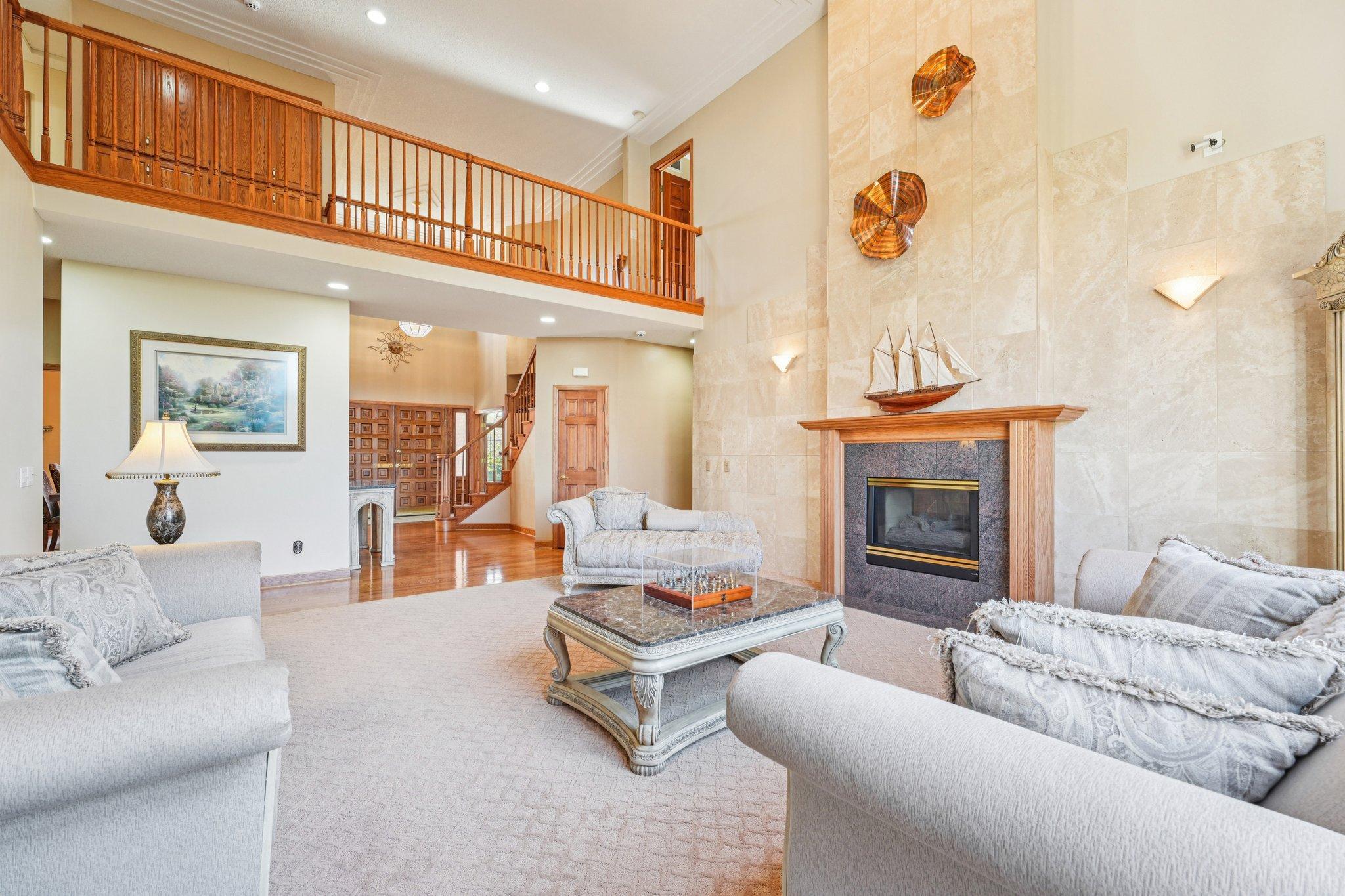 Welcome family and friends to gather in this bright and airy family room featuring vaulted ceilings, view of the catwalk that leads to the upstairs bedrooms and cozy gas burning fireplace.