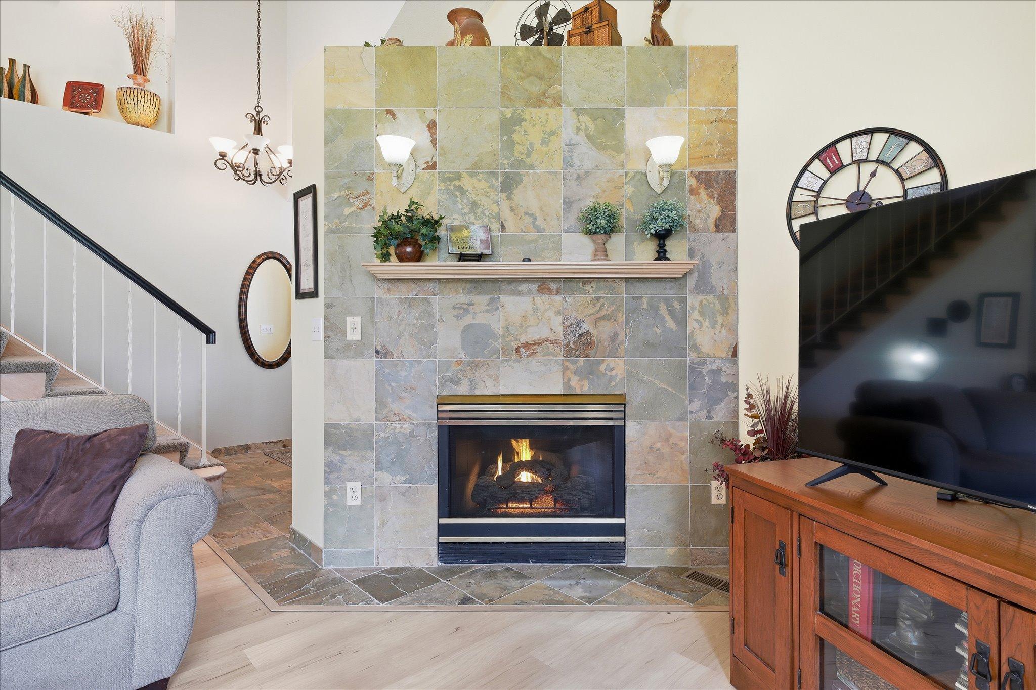 Beautiful gas fireplace with full tile surround and mantel, creating a warm focal point in the living room.